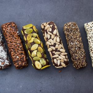 Chocolate energy protein bars with nuts, seeds, dry fruits. Healthy dietary snack. Vegan dessert. Chia, flax seeds, coconut, sesame, pumpkin, sunflower seeds.
